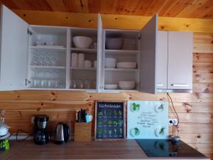 a kitchen with white cabinets and a shelf with dishes at House ThoNi in Gornji Štoj