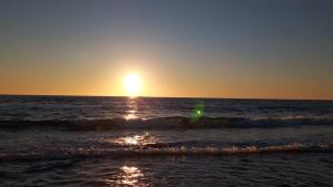 a sunset over the ocean with the sun setting at House ThoNi in Gornji Štoj
