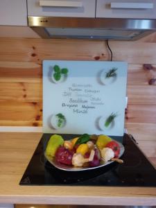 a plate of fruit on a table with a sign at House ThoNi in Gornji Štoj