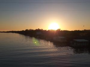 a sunset over a body of water with the sun setting at House ThoNi in Gornji Štoj