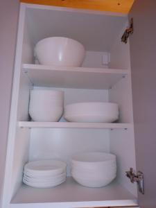 a closet filled with white plates and bowls at House ThoNi in Gornji Štoj