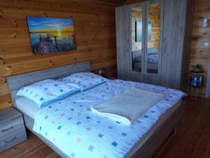 a bedroom with a bed in a log cabin at House ThoNi in Gornji Štoj