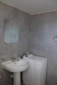a bathroom with a sink and a toilet and a mirror at House ThoNi in Gornji Štoj
