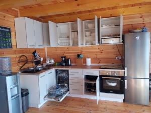 a kitchen with white cabinets and a stainless steel refrigerator at House ThoNi in Gornji Štoj