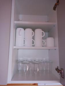 a shelf with cups and mugs in a refrigerator at House ThoNi in Gornji Štoj