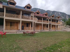 Woodridge Cottages Kalam في Kalām: مبنى كبير به كراسي وطاولات في الفناء