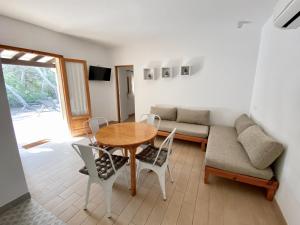 salon ze stołem, krzesłami i kanapą w obiekcie Campanitx Villas - Astbury Formentera w mieście Es Calo