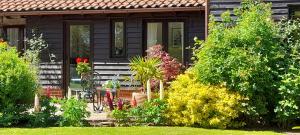 a small house with a garden in front of it at Cowpasture Barn B&B in Eye