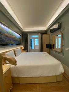 een slaapkamer met een groot wit bed met een schilderij aan de muur bij OHH -Oporto Center- Luxury Apartment in Porto