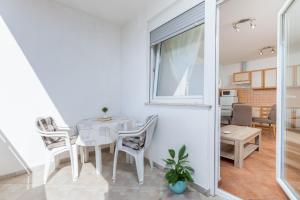une salle à manger avec une table et des chaises blanches dans l'établissement Cozy little place in amazing Istria, à Peroj