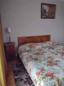 a bedroom with a bed with a floral comforter at Noclegi u Janika in Mizerna