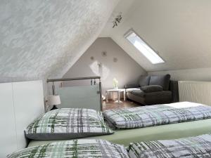 Schlafzimmer im Dachgeschoss mit 2 Betten und einem Sofa in der Unterkunft Ferienhaus Zum Gässchen in Weißenfels