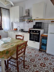 cocina con mesa y fogones horno superior en Casa sul mare Porto Torres III en Porto Torres