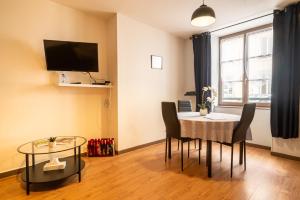 ein Esszimmer mit Tisch und Stühlen und einem Fernseher in der Unterkunft Le LENNON - Centre Ville T2 - Rez-de-chaussée in Limoges