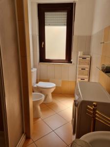 baño con aseo y lavabo y ventana en Casa sul mare Porto Torres III en Porto Torres