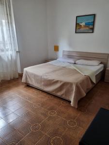 1 dormitorio con 1 cama con una foto en la pared en Casa sul mare Porto Torres III en Porto Torres