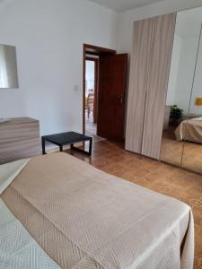 1 dormitorio con cama y espejo grande en Casa sul mare Porto Torres III en Porto Torres