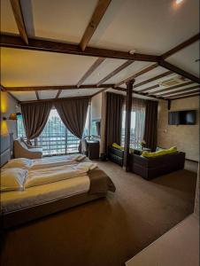 a bedroom with a large bed and a large window at Family Hotel Ognyanovo in Ognyanovo