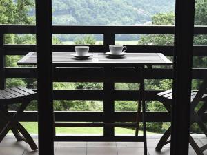 einen Tisch mit zwei Kaffeetassen auf einem Balkon in der Unterkunft Apartamentos Rurales El Mirador de San Juan in Cangas de Onís