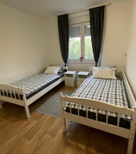 2 letti in una camera con finestra di Apartman Prima Sombor a Sombor