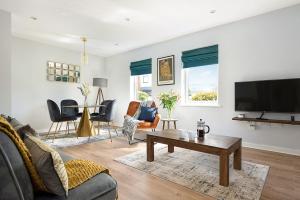 a living room with a couch and a tv at Stylish Serviced Apartment in Reading in Reading