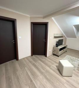 an empty living room with two doors and a stool at Vivko Apartments in Veliko Gradište