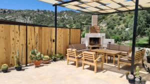 a patio with a table and chairs and a fireplace at Villa Camelion in Kaş