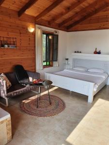 um quarto com uma cama, uma cadeira e uma mesa em Sharvit Hakesem em Livnim