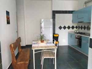 a small kitchen with a table and a refrigerator at Vivere il mare in Palinuro