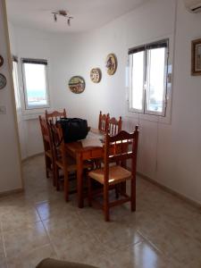 a dining room with a wooden table and chairs at Nautic in L'Ametlla de Mar