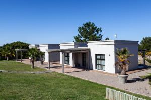 a white building with palm trees in front of it at Casa Chic Carmelo in Carmelo