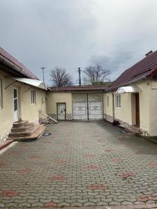 un edificio con garaje y entrada de ladrillo en Mountain Countryside House & Courtyard near Sibiu, en Orlat