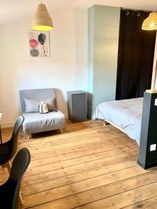 a room with a bed and a chair in it at LE DUMON 6 - Studio NEUF CALME - WiFi - GARE 200m in Agen