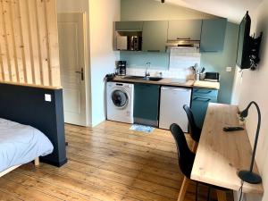 a small kitchen with a washing machine and a table at LE DUMON 6 - Studio NEUF CALME - WiFi - GARE 200m in Agen