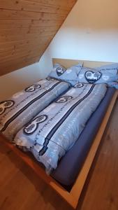 a bed with a blue comforter on top of it at Bright, sunny holiday apartment on the farm in Oberdiessbach