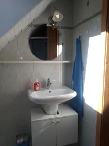 W łazience znajduje się umywalka i lustro. w obiekcie Bright, sunny holiday apartment on the farm 