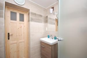 ein Badezimmer mit einem Waschbecken und einer Holztür in der Unterkunft Areál Přístav in Horní Soběšovice