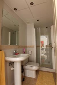a bathroom with a sink and a toilet and a mirror at Luxe appartement Las Palmeras Calahonda in Sitio de Calahonda
