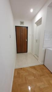 a hallway with a wooden door and a wooden floor at Bistrik Studio in Sarajevo