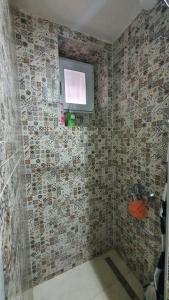 y baño con ducha y azulejos de mosaico. en Bistrik Studio, en Sarajevo