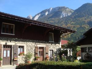 a stone house with a mountain in the background at Chez Mémé Cour in Bellevaux