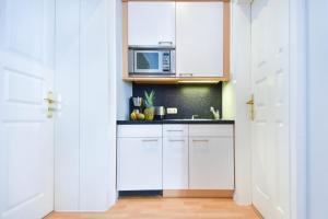 eine Küche mit weißen Schränken und einer Mikrowelle in der Unterkunft (61a) Villa Meeresblick 1 in Ahlbeck