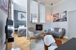 un salon avec un canapé, des fauteuils et une télévision dans l'établissement Villa Meeresblick Wohnung 2, à Ahlbeck