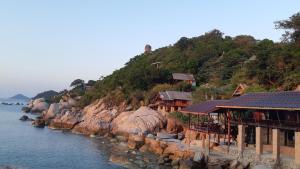 a group of houses on a hill next to the water at Tao Thong Villa 1 in Ko Tao