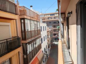 une allée entre deux bâtiments avec balcon dans l'établissement Apartamentos Casa May III - Centro Benidorm, à Benidorm