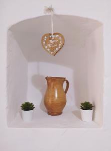 un jarrón y dos plantas en un estante con un corazón en Casa da Vela, en Rinella