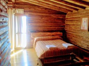 1 dormitorio con 1 cama en una cabaña de madera en Cabañas Walwalun en Tunuyán