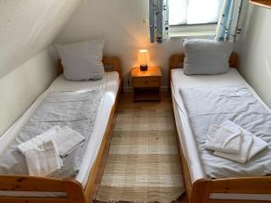 two twin beds in a small room with a window at Haus am Kurhaus 9 in Nordstrand