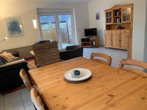 sala de estar con mesa de madera y sillas en Haus am Schilf en Nordstrand