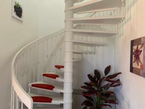 una escalera de caracol blanca con cojines rojos en Haus am Schilf en Nordstrand